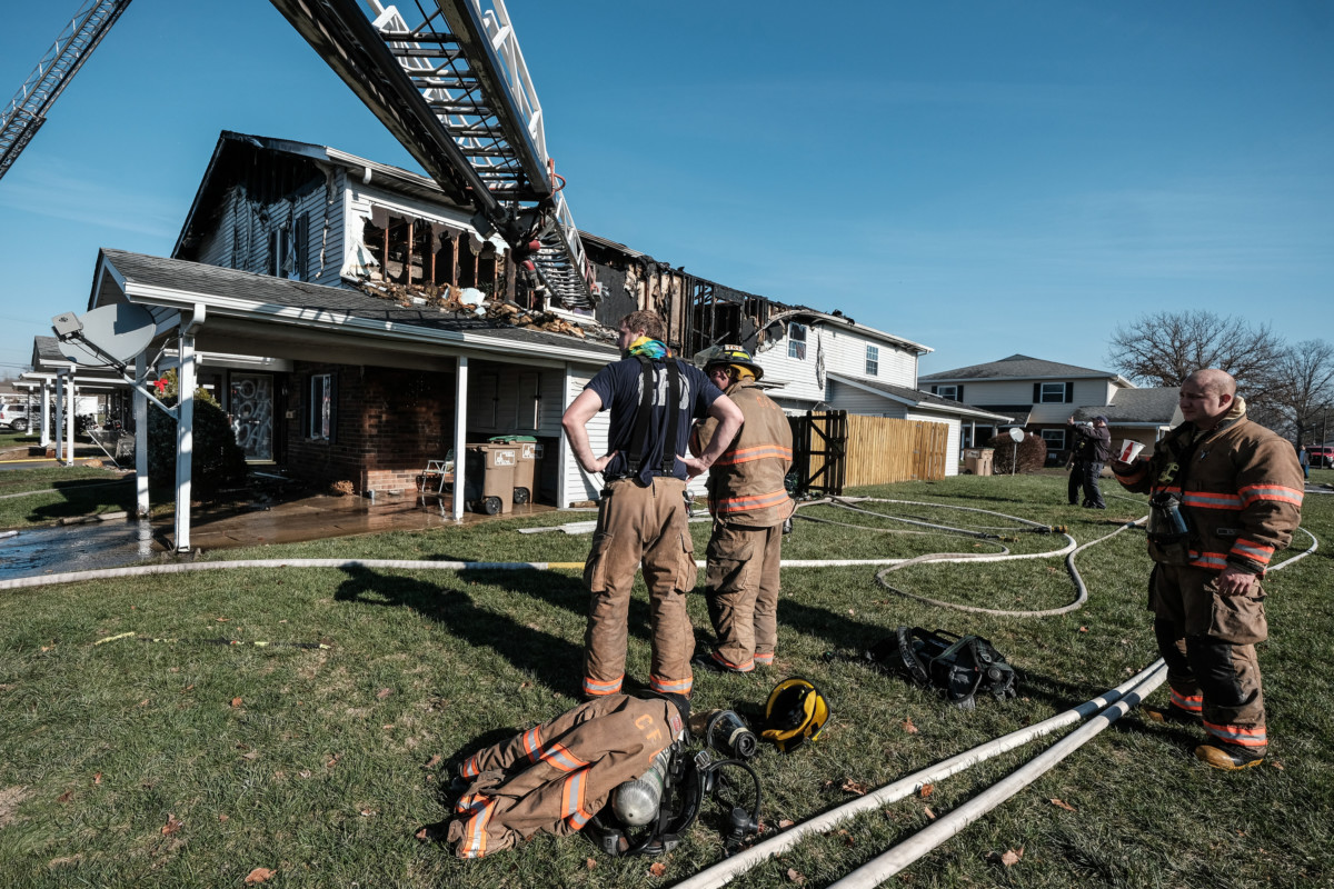 Columbus firefighters take a short break after working to extinguish a large structure fire at Two Worlds Condominium Association in Columbus, Ind., Wednesday, Dec. 6, 2020. Mike Wolanin | The Republic